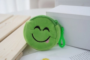 Detailed close-up of a green plush coin purse with embroidered smiling emoji face