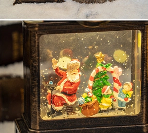 Close-up of vintage bronze Christmas water lantern with Santa and glitter snow