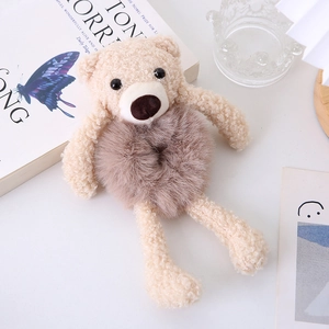 Detailed view of plush bear hair tie in light brown faux fur with soft texture