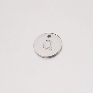 Macro shot of silver mirror-polished stainless steel 12mm round charm with letter Q