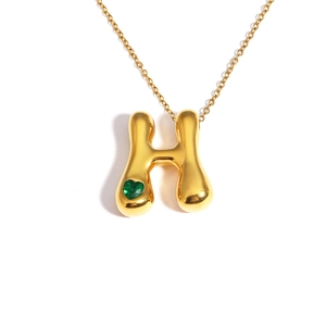 Polished 18k gold bubble letter H necklace with a green heart-shaped gemstone accent
