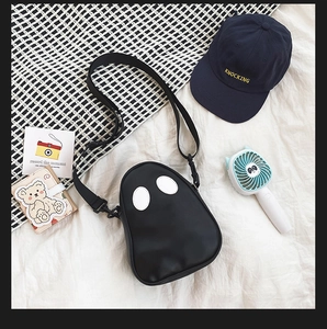 Detail view of ghost-shaped black PU leather crossbody bag with white eye appliques