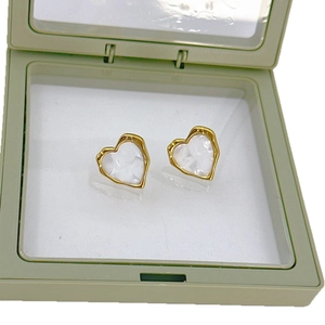 Vintage heart earrings with gold trim and white pearl inlay in a green jewelry display box