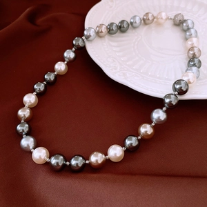 Détail d'un collier de perles multicolores sur une assiette en porcelaine en relief