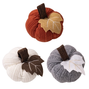 Three knitted pumpkin decorations in orange white and grey for Thanksgiving home decor