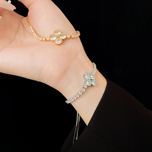 Detail of gold and silver four-leaf clover zircon bracelets with adjustable sliding chain