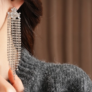 Dettaglio di orecchini vintage a nappa in argento con zirconi indossati da una modella