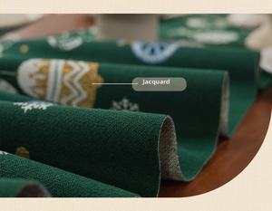 Detail of forest green Christmas table runner with festive jacquard snowflake patterns