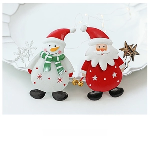 Detailed close-up of Santa Claus and Snowman Christmas pins on a white decorative plate