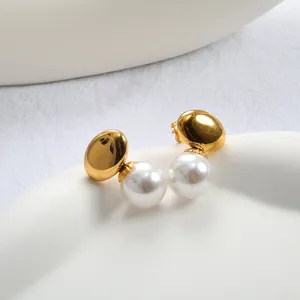 Close-up of elegant gold oval metal earrings with polished white pearl accents