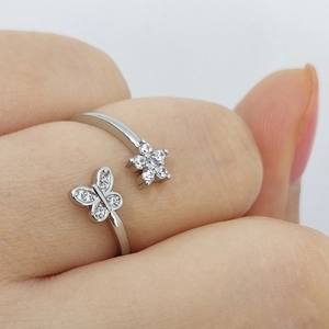 Silver open ring featuring butterfly and flower motifs with sparkling cubic zirconia