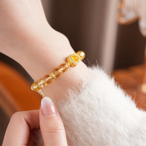 Gros plan détaillé du bracelet en perles de citrine avec breloque cœur doré au poignet