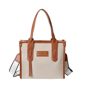 Beige canvas tote bag with brown leather trim and detachable shoulder strap for women