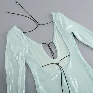 Detalle de vestido de lentejuelas verde menta con espalda en V, cordones negros y herrajes