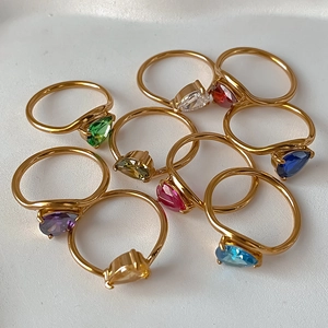 Macro shot of nine colorful pear-cut zircon rings with elegant gold plating finish