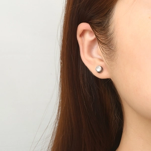 Minimalist punk stainless steel stud earring with round clear stone on model's ear