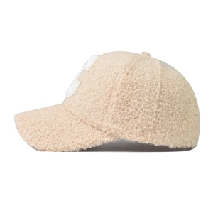 Beige faux shearling baseball cap featuring white letter embroidery and warm fleece texture