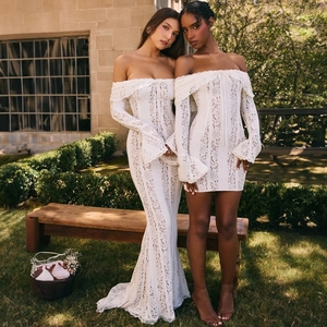 Detail of off-the-shoulder white lace dresses featuring floral patterns and flared sleeves