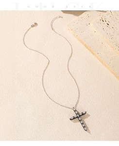 Close-up of retro black cross pendant necklace with marquise zircons and lobster clasp