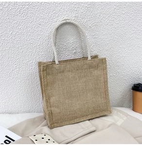 Close-up of woven jute tote bag with white cotton rope handles on neutral lifestyle background