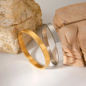 Polished titanium steel Roman numeral bangles in gold and silver finish on stones