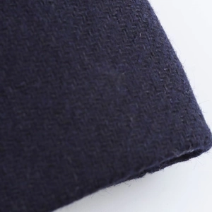 Close-up of premium dark blue wool blend fabric showing detailed woven texture and quality