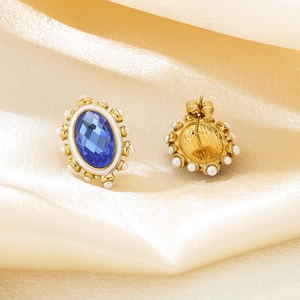 Retro oval blue gemstone earrings with pearl border on elegant silk background