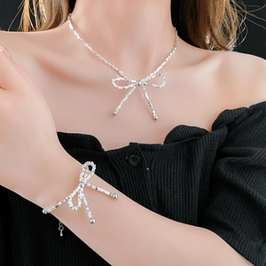 Close-up of elegant silver bow necklace and bracelet set worn by a model