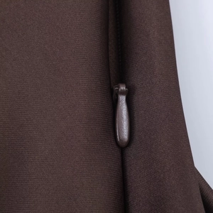 Detail of dark brown satin dress featuring a smooth hidden zipper and fabric texture