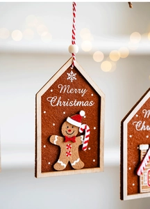 Detail of wooden house ornament with felt gingerbread man and festive candy cane decor