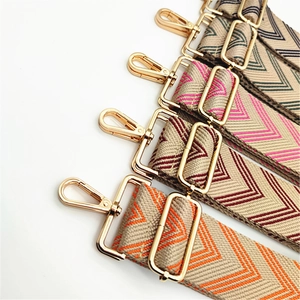 Detail of colorful herringbone woven bag straps with adjustable gold metal buckles