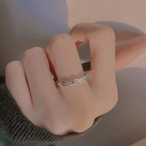 Macro shot of silver intertwined knot ring featuring a delicate micro-pave setting