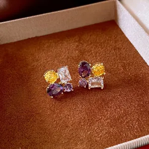 Luxurious gold earrings featuring colorful zircon oval stones in a velvet jewelry box