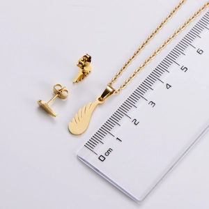 Detailed measurement of gold angel wing necklace and earrings set using a clear ruler