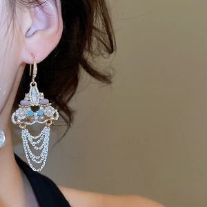 Close-up of vintage gold tassel earrings with crystal beads on woman's ear