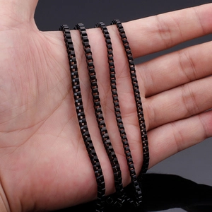 Handheld view of a matte black stainless steel box chain necklace with cubic link structure