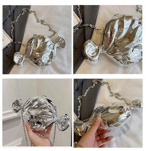 Detail of silver candy-shaped shoulder bag with irregular fluid wrinkles and metal chain