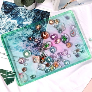 Macro view of transparent green resin tray mold with various DIY glitter accessories