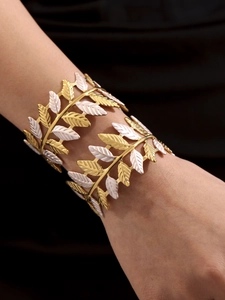 Dettaglio del bracciale a foglia bicolore oro e bianco con trame di venature incise
