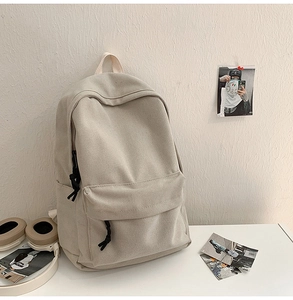 Detailed macro view of durable canvas texture and front zipper on the beige backpack