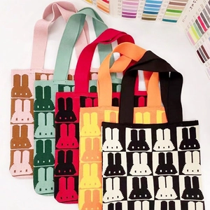 Five colorful knitted tote bags with cartoon rabbit patterns and woven handles
