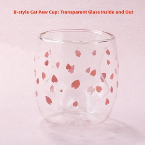 Close-up of double-walled glass cup with cat paw shape and pink cherry blossom petals
