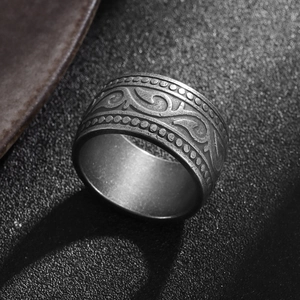 Macro shot of vintage titanium steel ring with embossed floral vines and relief patterns