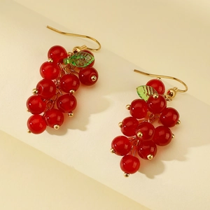 Detail of red grape berry earrings with green leaves and gold metal hooks