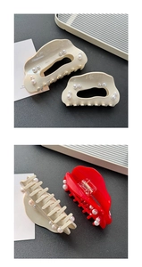 Close-up of elegant acetate hair claws in beige and red with inlaid pearl accents