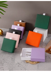 Close-up of colorful drawer jewelry boxes with satin ribbons and earring inserts