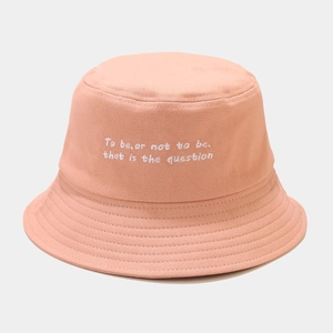 Detailed white embroidery on a coral pink canvas bucket hat with poetic text design