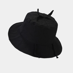 Detail of black cotton bucket hat with cute horn accents and adjustable chin straps