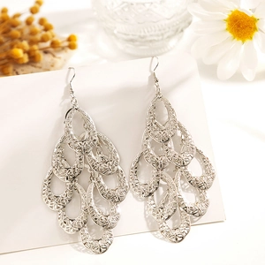 Vue macro de boucles d'oreilles argentées évidées à plusieurs couches en gouttes