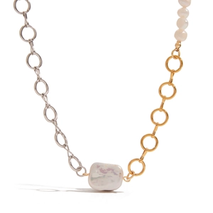 Close-up of bicolor steel chain necklace featuring a large white baroque pearl pendant